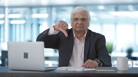 Angry-senior-Indian-businessman-showing-thumbs-down