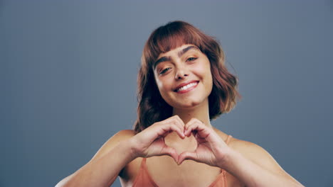 una mujer joven haciendo una forma de corazón con sus manos