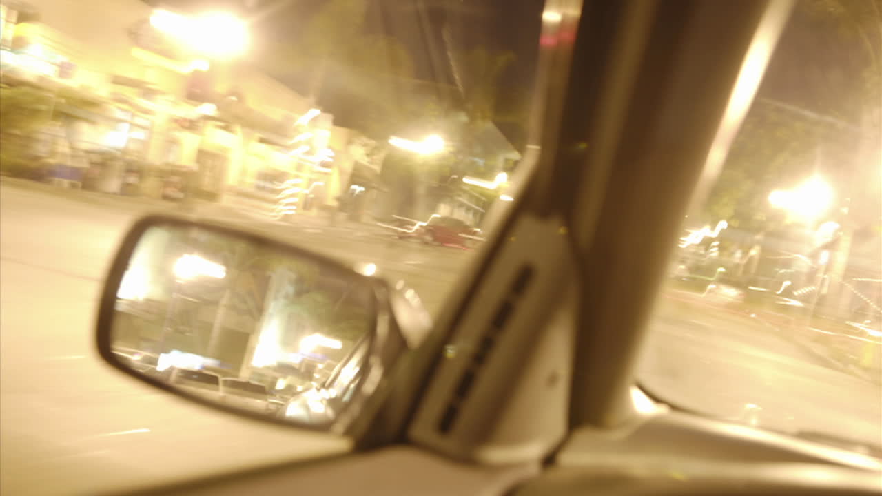 한 사람이 밝은 도시 거리를 통해 차를 운전한다 1