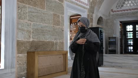 mujer musulmana enmascarada orando en la mezquita