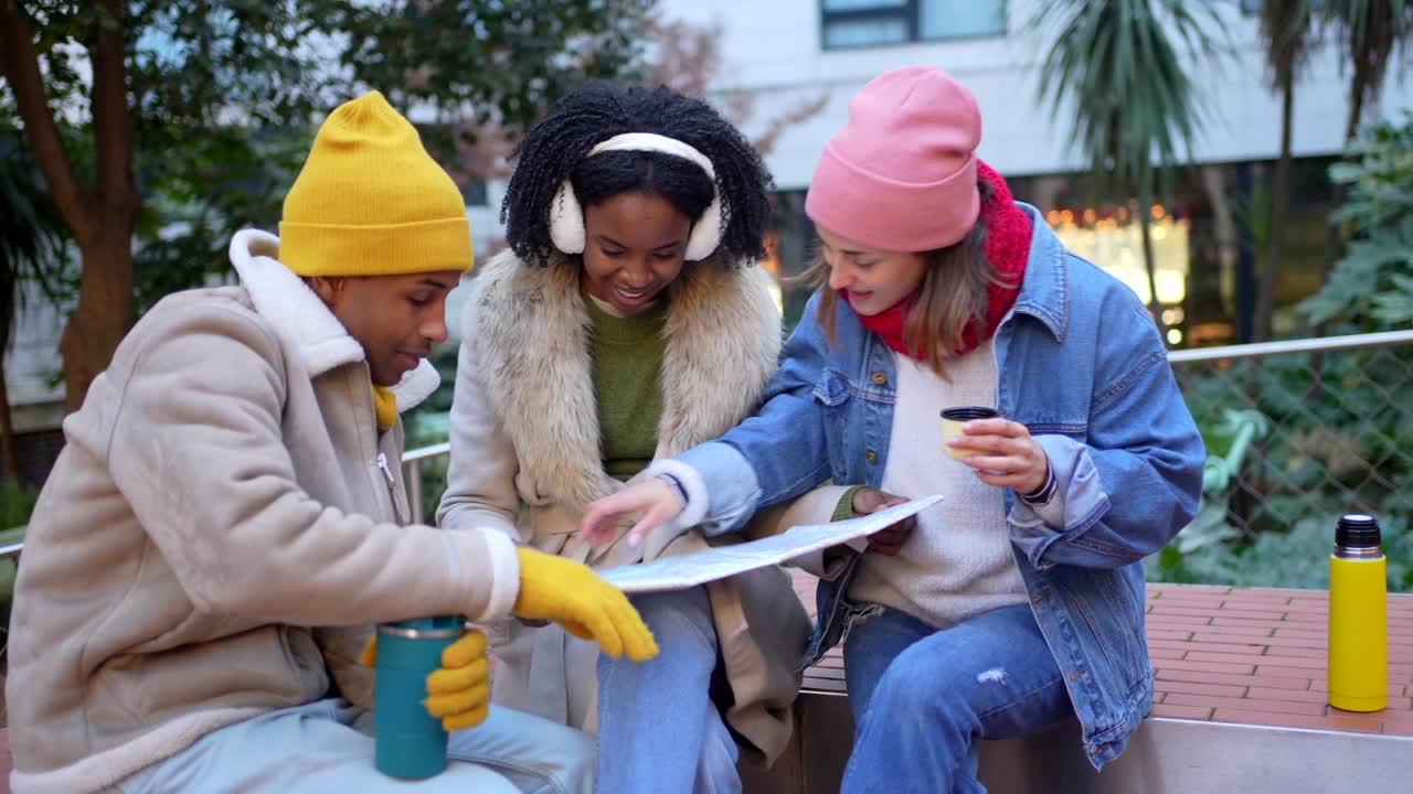 Friends planning trip using a map outdoors