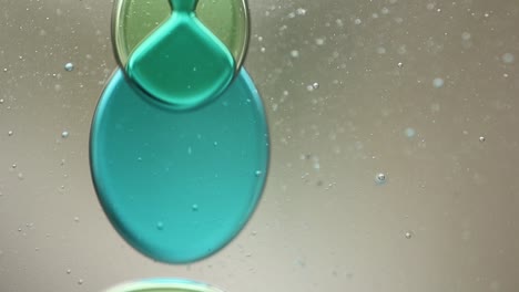close-up of blue and green liquid with floating bubbles and blobs in motion inside a lava lamp, viewed in a horizontal orientation. hypnotic and abstract visual texture