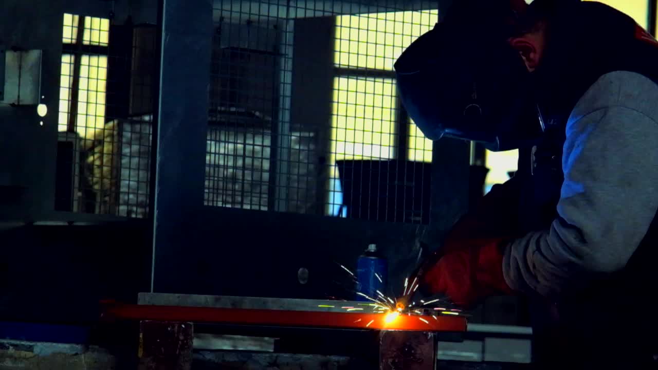 Man in workshops doing mig welding in slow motion