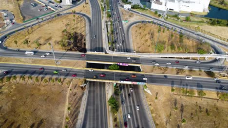 Eine-Stark-Befahrene-Autobahn-Oder-Autobahnkreuzung-In-Mexiko-Mit-Stark-Befahrenen-Straßen-Und-Trocken-Wirkendem-Industrieland-Rundherum