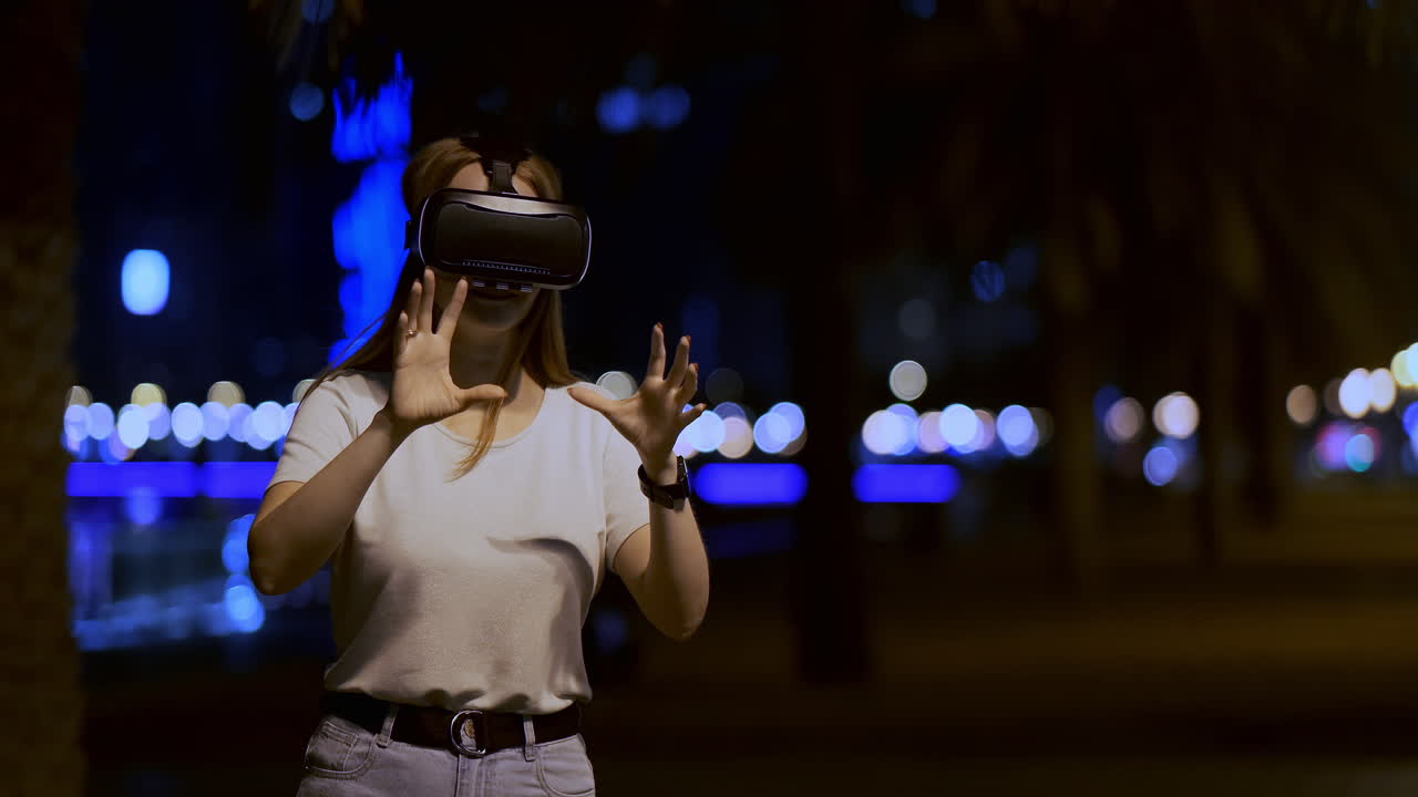 una giovane ragazza con gli occhiali di realtà virtuale in una grande metropoli simula il lavoro nell'interfaccia di realtà virtual del gioco di programmazione. il concetto di realtà aumentata