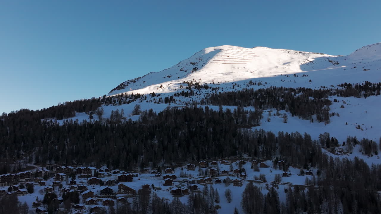 Drone aerial of Chandolin, Switzerland. Traditional alpine village with wooden chalets, snowy slopes and mountain peaks. Perfect winter tourism, travel and cinematic stock footage