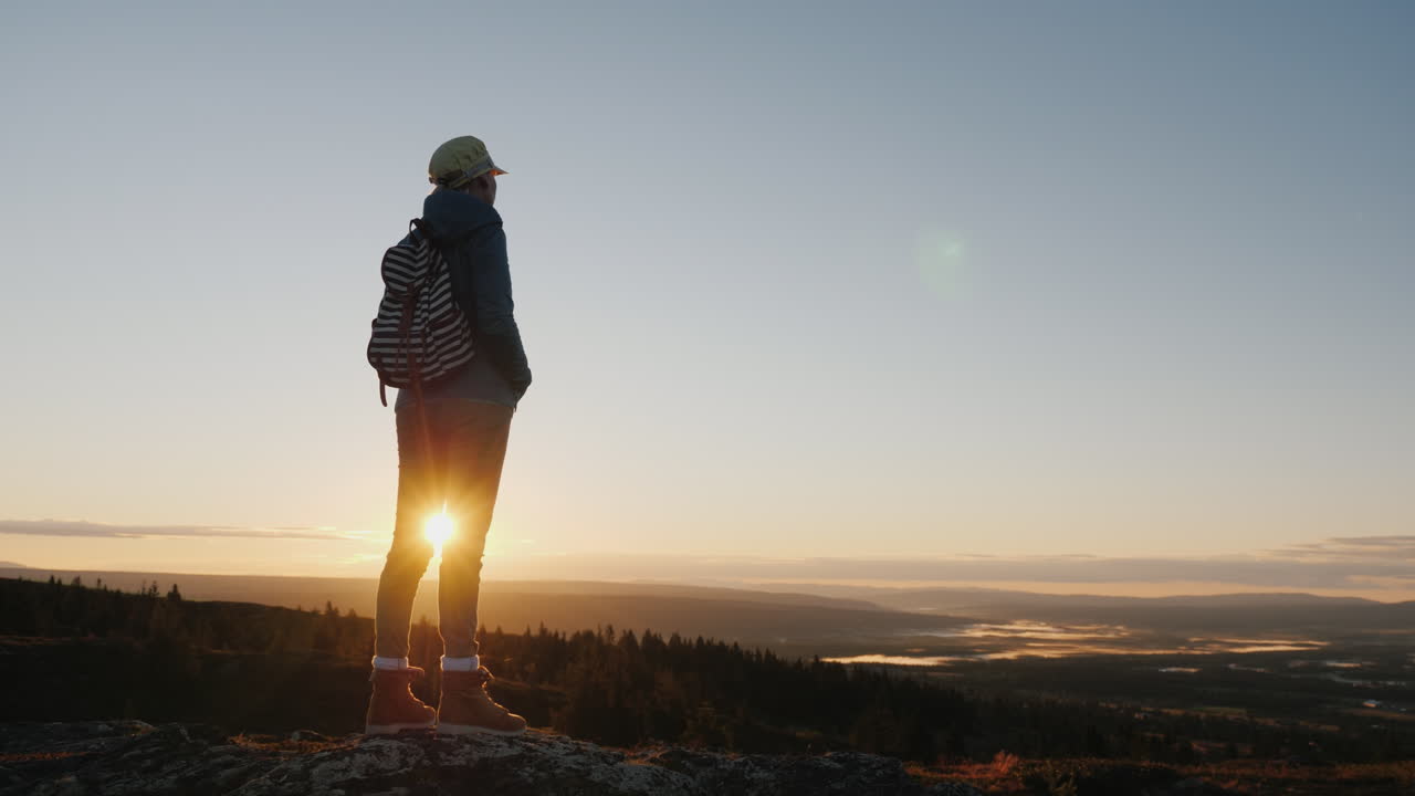 una mujer viajera se encuentra en la cima de una montaña mira el hermoso paisaje por delante admira la natu