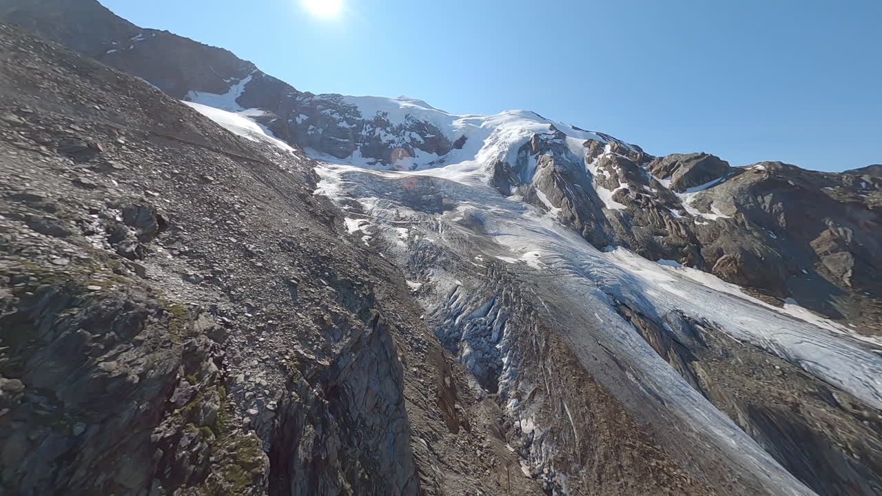 FPV drone flying through the exposed Weismies glacier above Saas-Grund, revealing deep crevasses, seracs, and signs of rapid glacial melt. The Swiss Alps in all its beauty