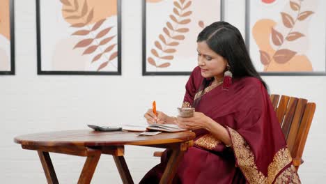 happy indian woman doing household accounts