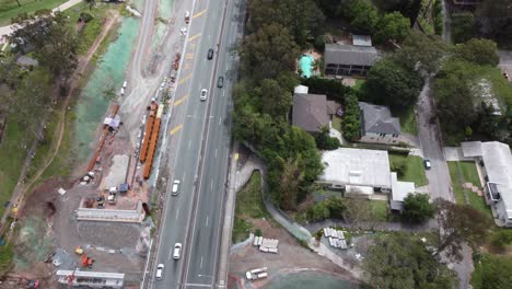4K aerial view of a construction site near a highway and a brown river in Australia