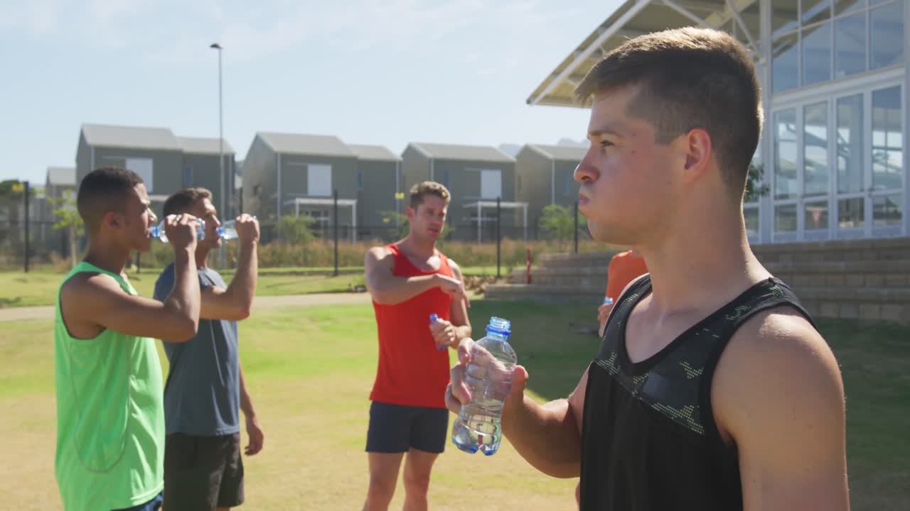 hombres bebiendo agua después del entrenamiento en un día soleado