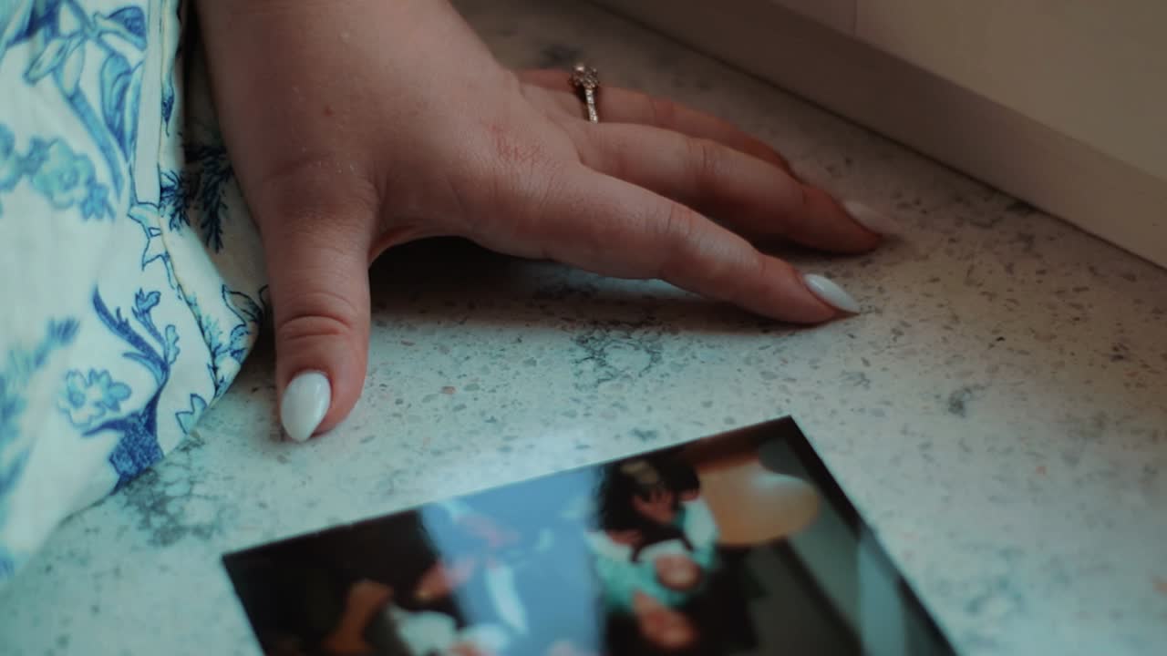 ricordi una ragazzina è seduta vicino alla finestra tenendo la mano sul davanzale davanti a lei c'è una foto