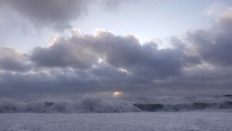 big waves at rejnisfjara black sand beach in iceland with a big cloud when sunset in january