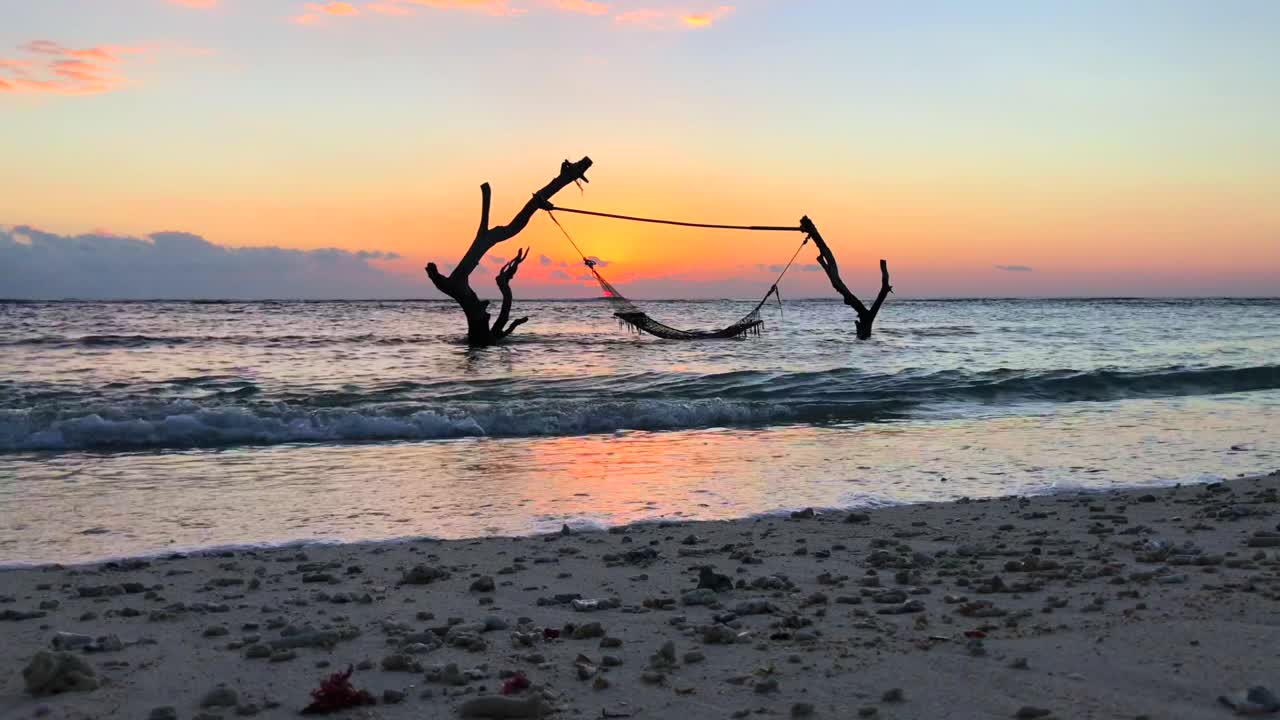 Rede na água em Gili Trawangan com vista para o pôr do sol, Bali, Indonésia