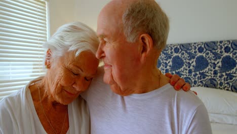 Front-view-of-Caucasian-senior-couple-embracing-each-other-in-bedroom-at-comfortable-home-4k-