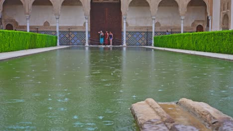 rainy day at the pool of courtyard of the myrtles in alhambra, granada, spain