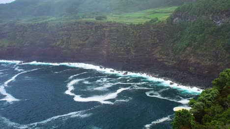 waves hitting the rocky coastline and cliff of terceira island in azores, portugal