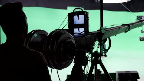 film crew in green studio shooting video. chroma - technology of combining two or more images or frames in single composition. cameraman, director, crew. filmmaking industry.