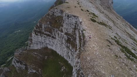 Chica-Corriendo-En-La-Cima-De-Una-Montaña-Peligrosa,-Practicando-Trail-Running-O-Skyrunning,-Increibles-Vistas-Al-Acantilado,-Navarra-Beriain