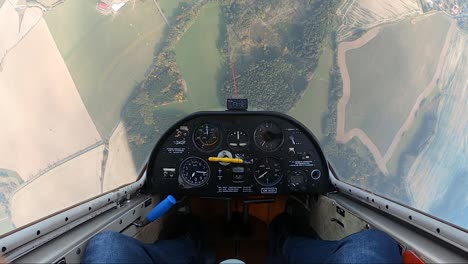 dando vueltas en un planeador, deteniéndose en el aire y luego volando de cabeza sobre campos y bosques, el punto de vista del piloto desde una cabina