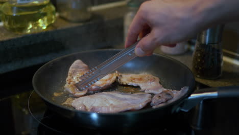 asar rebanadas de carne de cerdo en la sartén en casa