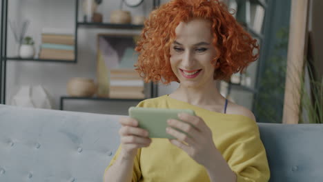 mujer usando teléfono inteligente en el sofá