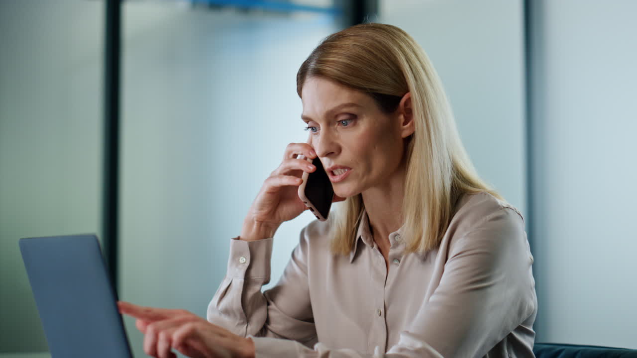 Serious manager discussing phone call closeup. Focused woman pointing laptop