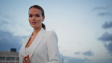 walking businesswoman looking camera enjoying cloudy evening weather close up.