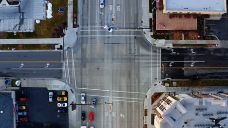 bird's eye aerial drone top view of a busy intersection with cars passing by in downtown provo, ut