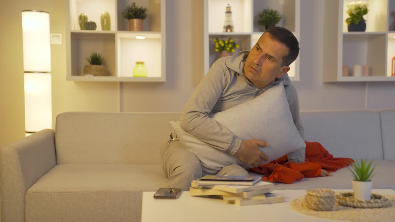 침대에서 두려움과 불안으로 주위를 둘러보는 남자.