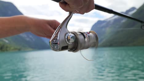 mujer pescando en una caña de pescar girando en noruega.