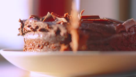 side view of knife cutting delicious milk chocolate cake dessert with shallow dof. served at birthday parties or afternoon tea. food photography.