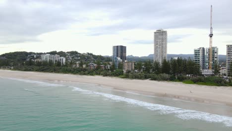 aerial view of sandy beach and cityscape at daytime in burleigh heads, gold coast, queensland, australia - drone shot