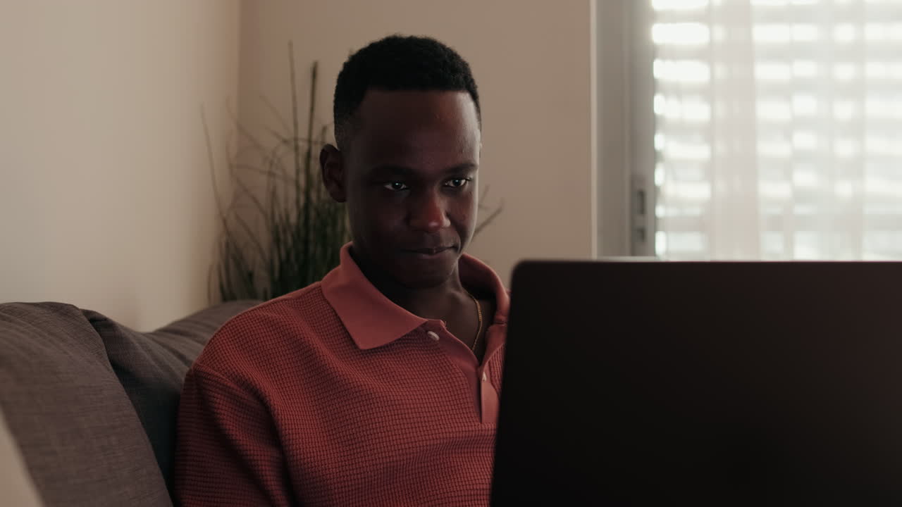Young Black Man Focused on Laptop Screen at Home