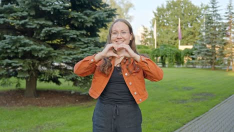 heart with hands gesture: brunette expresses romantic sentiment to camera with joy