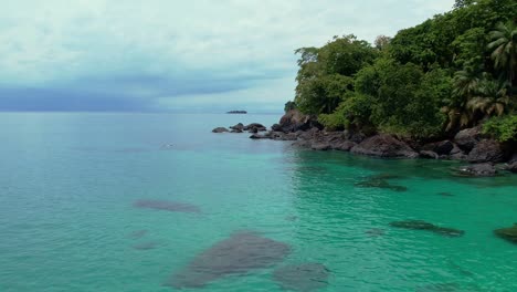 drone flyover turquoise colored water in tropical island, african paradise