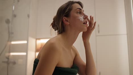 mujer aplicando una máscara facial