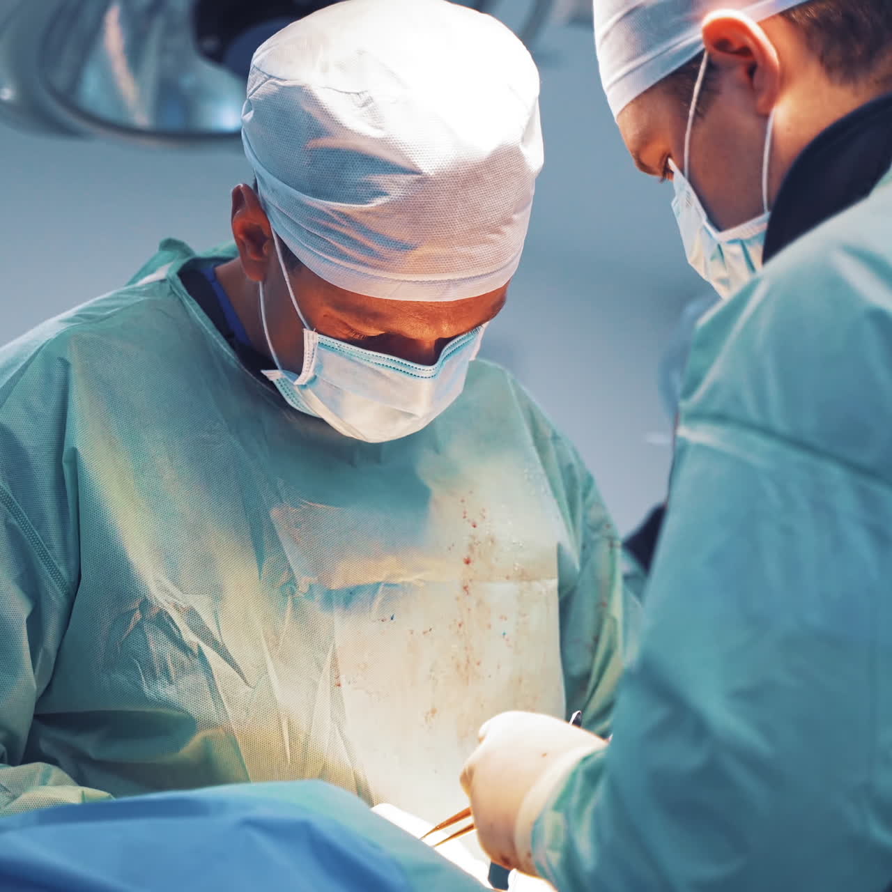 Specialist in medical masks perform an operation. Male surgeons working with patient in the operating room. Neurosurgery.
