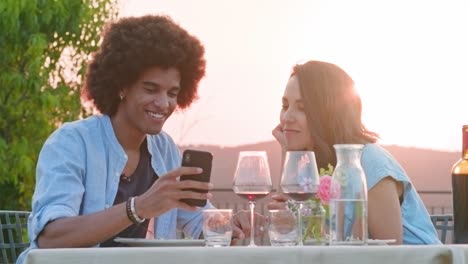 man ans woman using smartphone device taking a selfie during romantic outdoor dinner at sunset .friends italian trip in umbria.4k slow motion