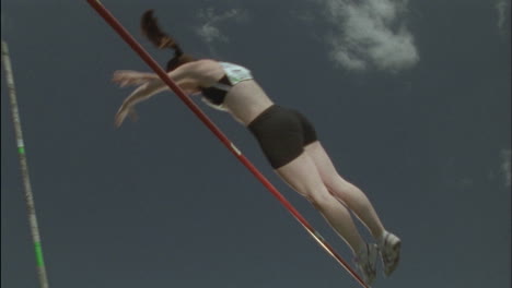 a female athlete competes in pole vaulting