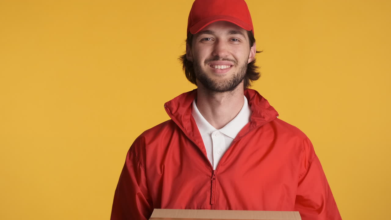 Caucasian delivery man in front of camera on white background.