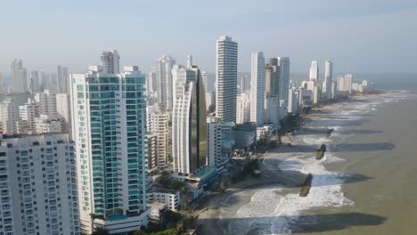 Drone-Flies-Above-Beaches-in-Cartagena,-Colombia-as-Waves-Crash-on-Coastline