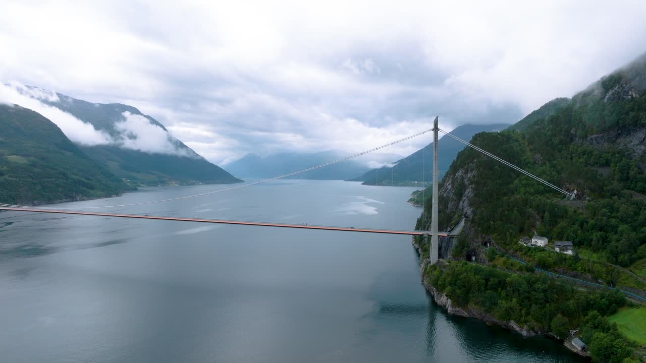 Hardanger bridge in Norway on cloudy rainy day, drone orbit