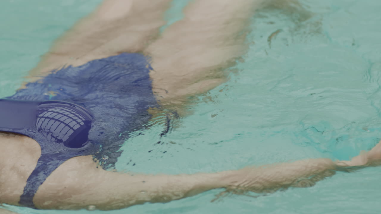 mujer irreconocible relajándose en el agua en la piscina