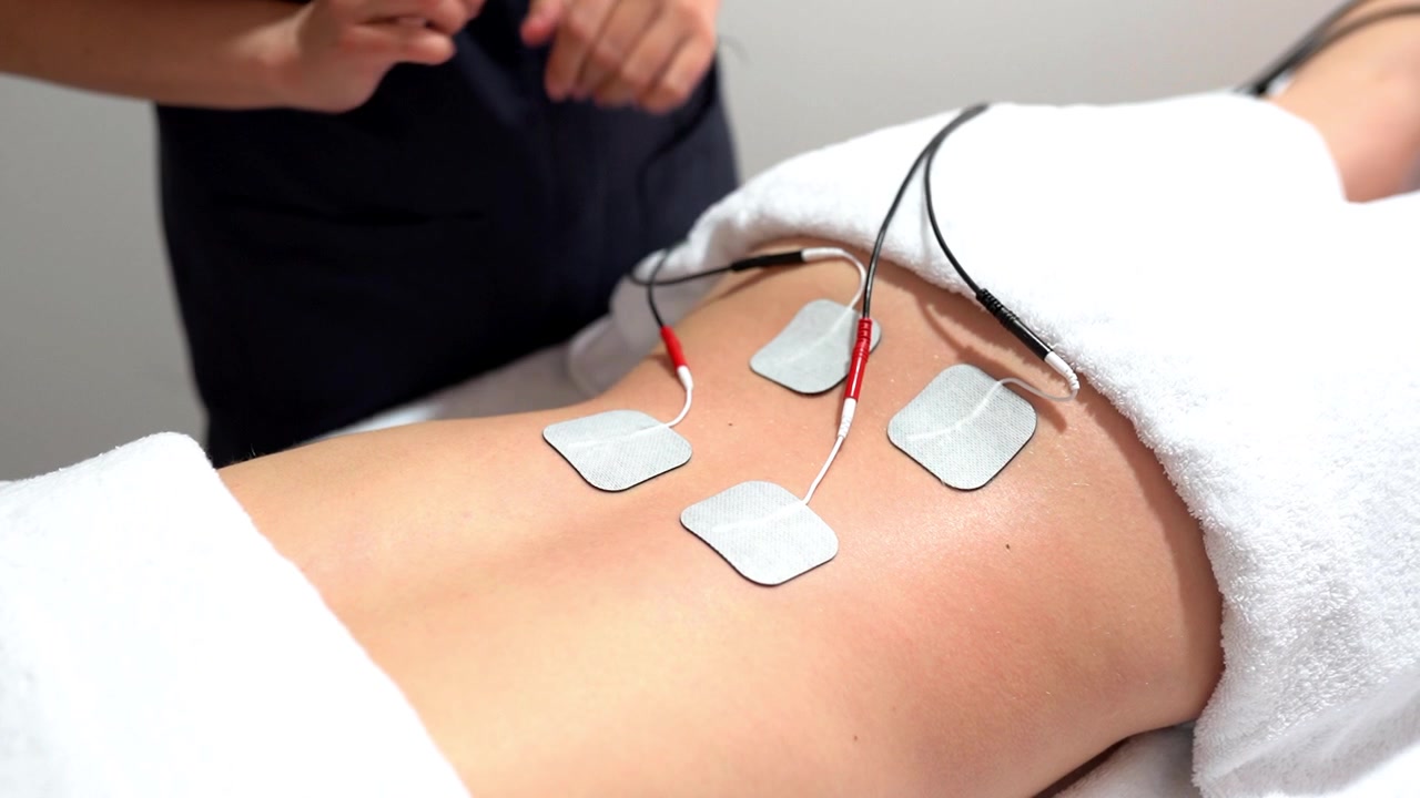 Electro stimulation in physical therapy to a young woman