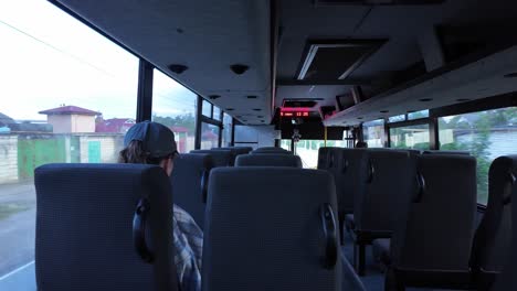 a view from the back of a bus driving through a city on a sunny afternoon