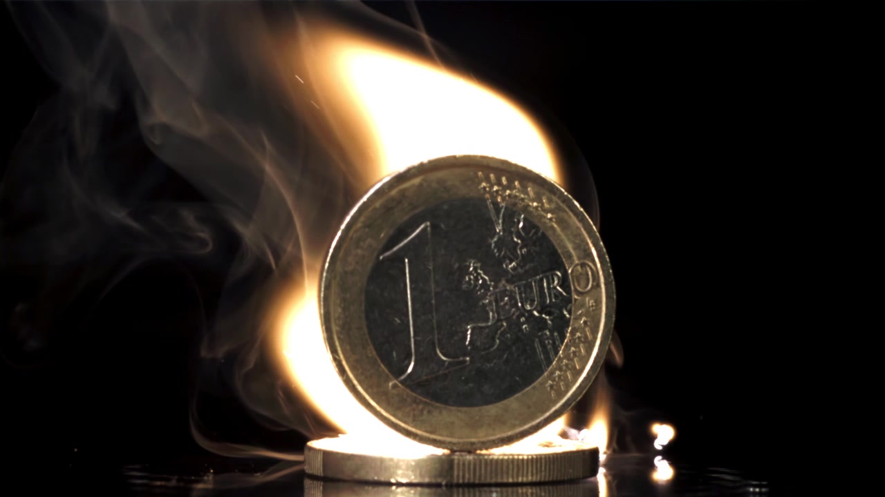 Moneta da Euro che brucia con fumo e fiamma su sfondo nero
