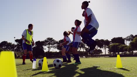 jugadoras de fútbol saltando en el lugar mientras el capitán da entrenamiento. 4k