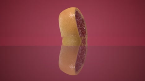 two fresh grapefruit emerging from the center of the frame hanging in the air and falling down
