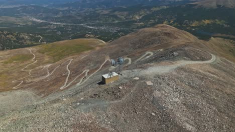 aerial view of a winding mountain road leading to a communication tower